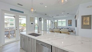 A modern kitchen with a large island, stainless steel appliances, and pendant lighting. - Casa Playa~ Luxury Pool Home Amazing Outdoor Area! (Marathon)