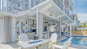 A multi-level outdoor living area with a pool, seating, and a kitchen area. - Casa Playa~ Luxury Pool Home Amazing Outdoor Area! (Marathon)
