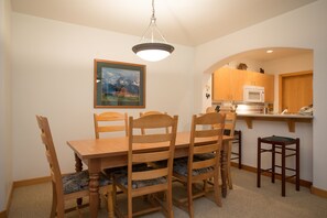 Enjoy meals in this cozy dining area with a wooden table and comfortable chairs.
