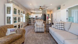 A spacious living room with a sofa, armchairs, and a coffee table. There is a kitchen area in the background with cabinets and a dining table. - Island Time~ Pool Home Seconds to Open Ocean! 26' Dock (Marathon)