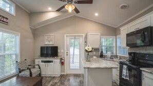 A modern kitchen with a central island, built-in appliances, and a ceiling fan.