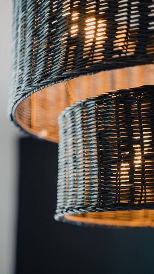 A close-up of a woven light fixture with a warm glow. - Auberge Chic -Verdure: Holiday Magic by the Sea (St. Augustine Beach)