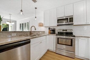 Enjoy cooking in this well-equipped kitchen with a double sink, oven, and microwave.