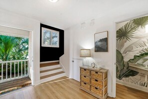 Stunning interior with a wooden staircase, white-framed window, and a cozy reading nook.