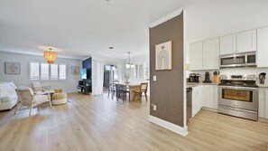 Enjoy a spacious living area with a sofa set and dining table, plus a fully equipped kitchen with microwave, oven, and coffee maker.