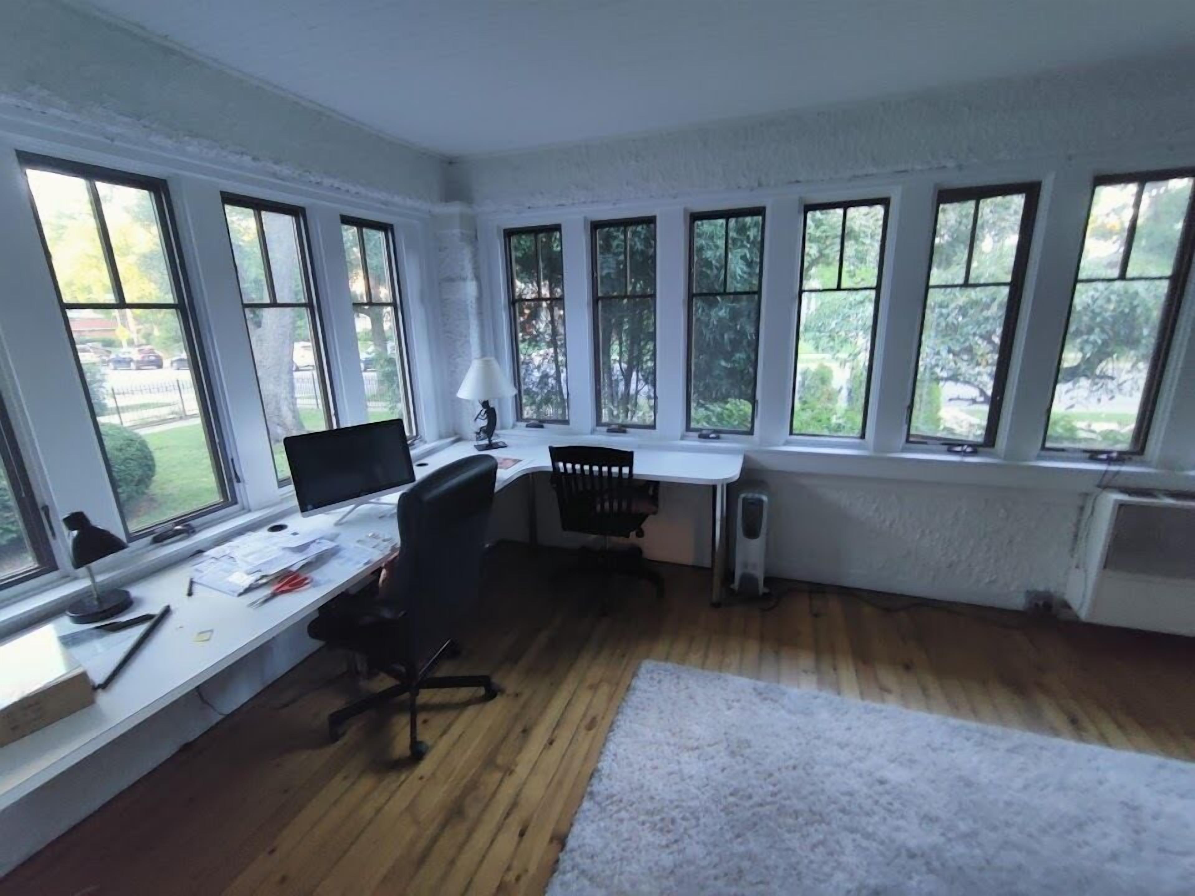 Une pièce dotée d’un bureau, d’un ordinateur et de plusieurs fenêtres.