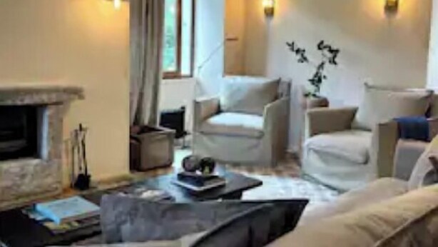 A modern living room with a fireplace, two armchairs, a sofa, and a coffee table. - Luxury hideaway in PDS - The Stonehouse Front Door (Saint-Jean-d'Aulps)