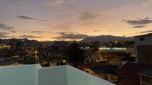 A residential area with houses and a mountain range in the background.