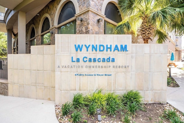 Señal de Wyndham La Cascada, un resort de propiedad vacacional, con fachada de piedra y ventanas arqueadas.
