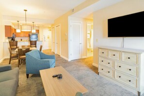 Ein modernes Wohnzimmer mit einer Couch, einem Couchtisch und einem an der Wand befestigten Fernseher.