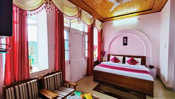 Una habitación de hotel con cama, sofá, mesa de centro y ventilador de techo.
