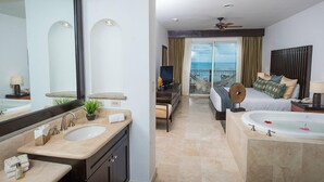 A modern hotel room with a large mirror, a bathtub, a balcony with a view, and a television. - Cancun 5 stars Luxury Resort and Spa, 1 bedroom suite, 2 baths, sleep 4 (Punta Sam)