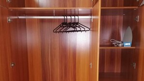 A wooden wardrobe with multiple shelves and a hanging rod. - DALM-D Cozy lovely studio with Gym in Kileleshwa (Nairobi)