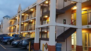 A multi-story hotel with balconies, a parking area, and a staircase. - Ashland Studio Inn By OYO Richmond North near Kings Dominion (Ashland)