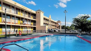 A hotel with a swimming pool, multiple balconies, and a parking area. - Ashland Studio Inn By OYO Richmond North near Kings Dominion (Ashland)