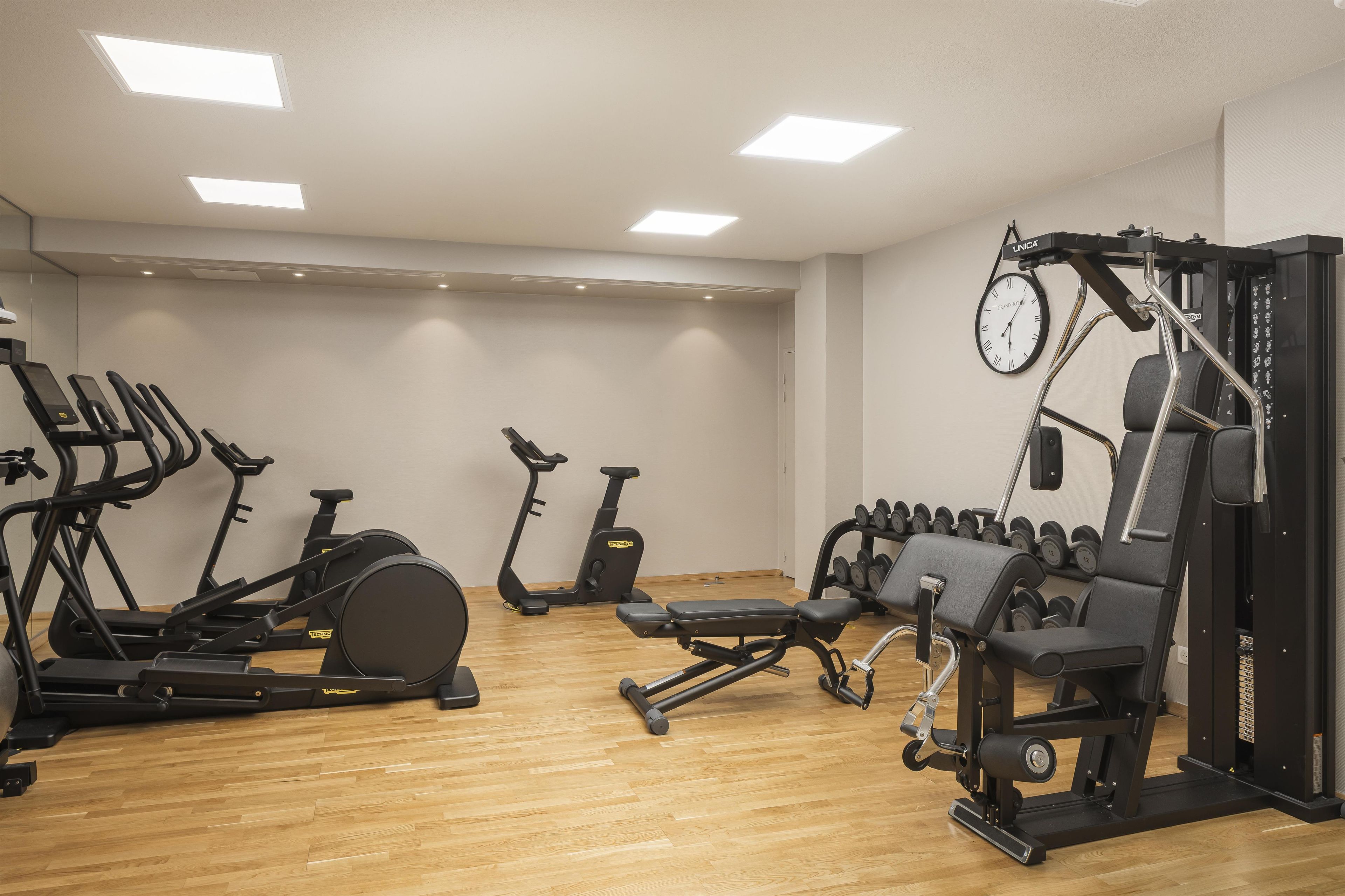 A gym with various exercise equipment including treadmills, stationary bikes, and weight machines.