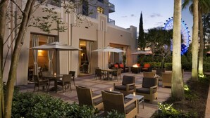 Une terrasse extérieure avec des sièges, un foyer et une grande roue en arrière-plan.