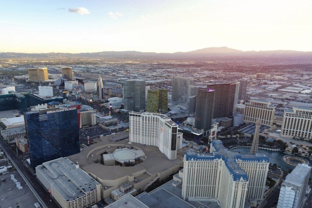 A high-rise hotel with a circular courtyard, surrounded by other buildings.