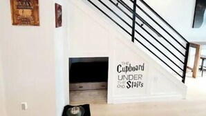 A staircase with a black railing and a sign that reads "Cupboard Under the Stairs." - Local Host: 3BR 2.5BA by BSU DT GreenBelt & Skiing (Boise)