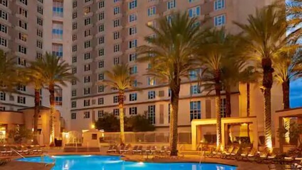 A hotel with a swimming pool, palm trees, and a multi-story building. - Paradise, a Hilton Grand Vacations Club - 1 Bedroom - EP (Las Vegas)