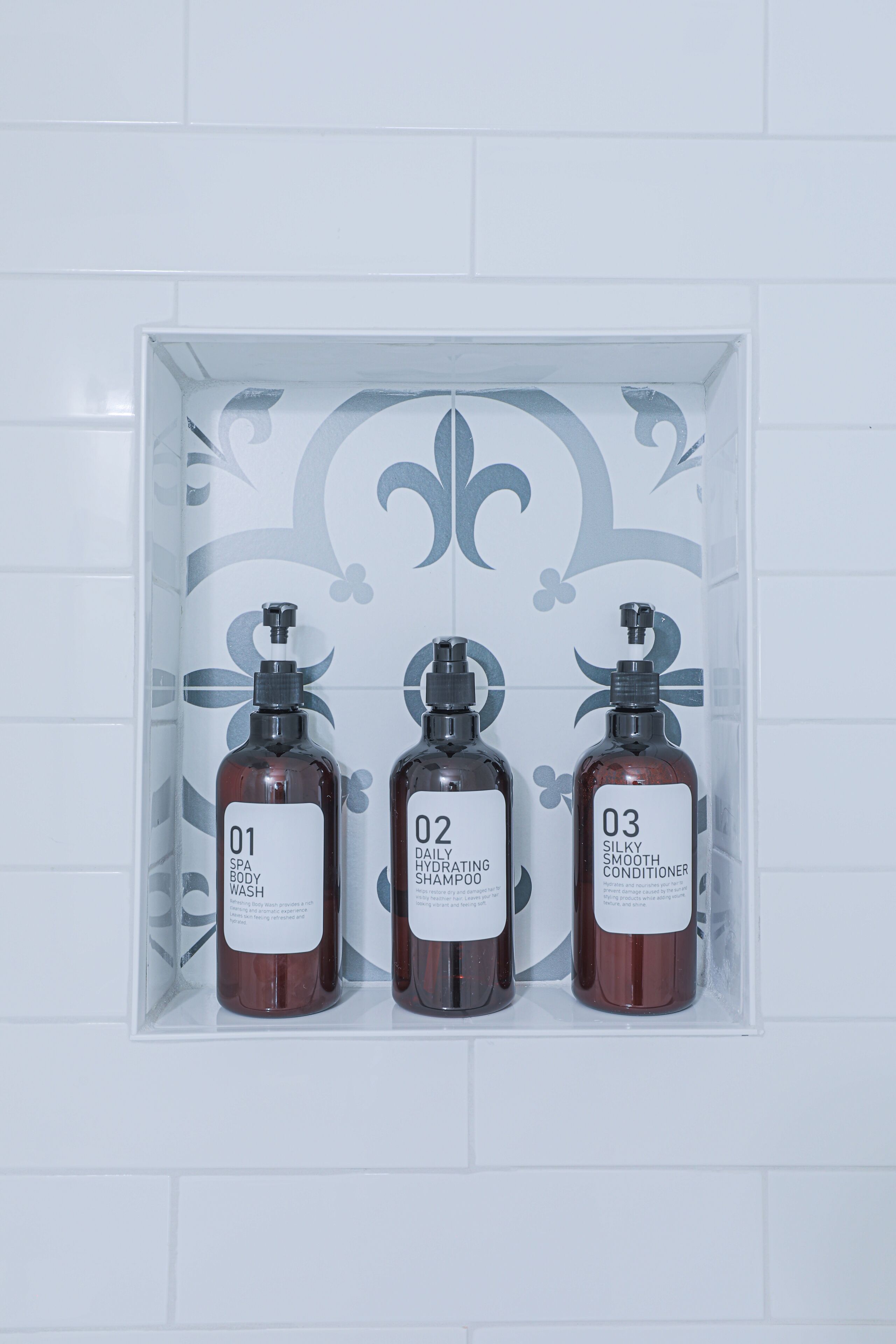 Une étagère de salle de bain avec trois flacons de produits de toilette étiquetés 01, 02 et 03.