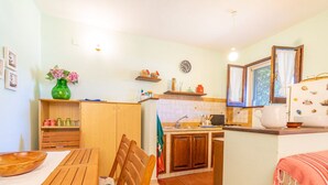 Une cuisine de taille réduite, avec des meubles de rangement en bois, une table à manger et une petite fenêtre.