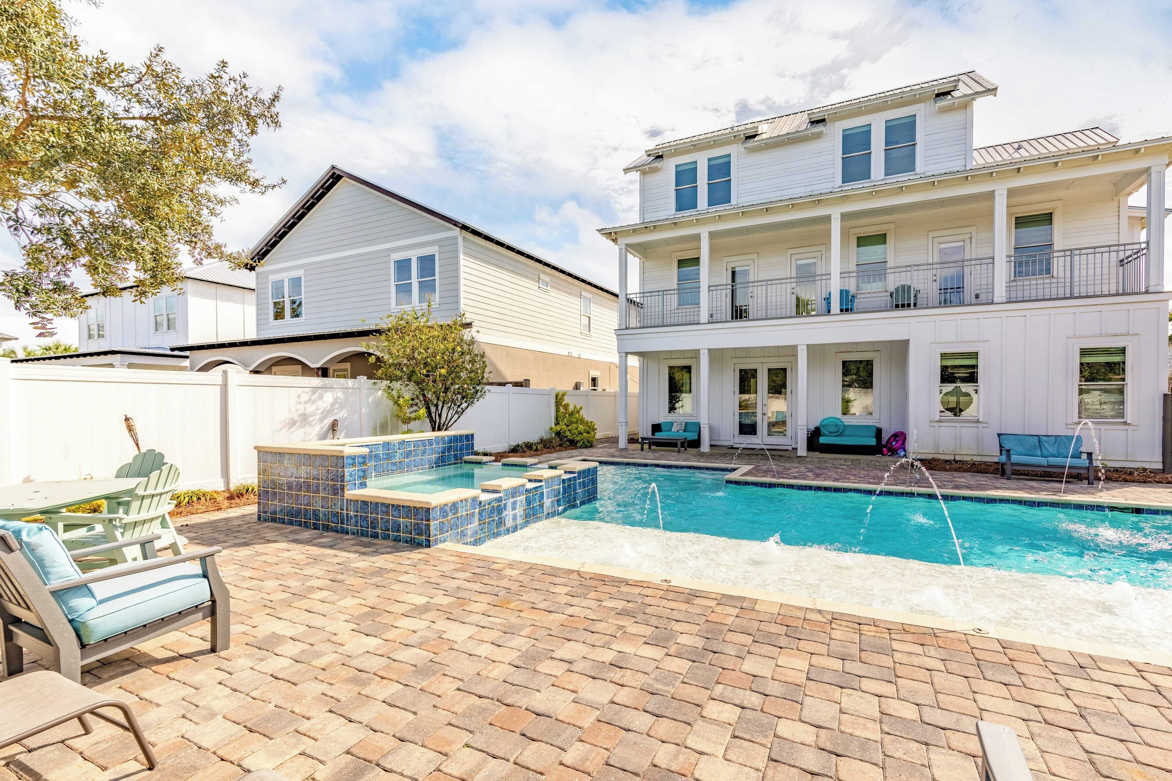 Ein zweistöckiges Haus mit Swimmingpool, Außenbereich und überdachter Terrasse.