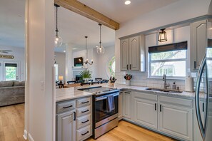 A modern kitchen with white cabinetry, a built-in oven, and pendant lighting. - Magnolia Charms by Avantstay 2 Mins TO Beach Pet Friendly, BBQ & Balcony Views! (Destin)