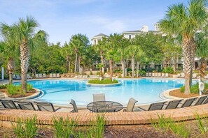 A pool area with lounge chairs and palm trees.