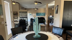 A dining area with a round table, chairs, and a decorative glass centerpiece. - RANCHO MIRAGE - VICTORIA FALLS ENTERTAINING 4 BD - HUGE POOL & SPA & GRASS YARD! (Rancho Mirage)