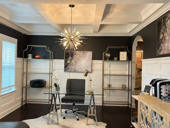 A modern office space with a glass desk, black office chair, and a unique ceiling light fixture. - LUX House! HOT TUB! 4 min to campus. Golf lot (Auburn)