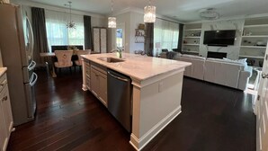 A modern kitchen with a central island, stainless steel appliances, and pendant lighting. - LUX House! HOT TUB! 4 min to campus. Golf lot (Auburn)