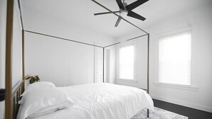 A bedroom with a bed, a ceiling fan, and two windows with blinds. - 191 Seymour, Ave. Derby · Spacious Renovated 3 bedroom near GriffinHospital (Derby)