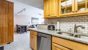 A kitchen with wooden cabinets, a granite countertop, a dishwasher, and a sink. - Comfy 1 bed/1 bath - 6 blocks from Mayo (Rochester)