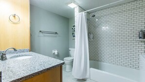 A bathroom with two sinks, a toilet, a shower, and a towel rack. - Comfy 1 bed/1 bath - 6 blocks from Mayo (Rochester)