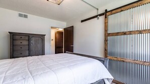 A bedroom with a bed, a dresser, a wardrobe, and a ceiling light fixture. - Modern, Rustic 2 Bed/1 bath 6 blocks from Mayo (Rochester)