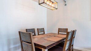 A dining table with six chairs, a wooden floor, and a hanging light fixture. - Modern, Rustic 2 Bed/1 bath 6 blocks from Mayo (Rochester)