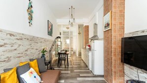 A modern living room with a sofa, a dining area, and a kitchen. - San Fernando Garden (Alicante (Alacant))