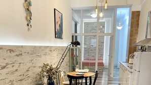 A modern living room with a grey sofa, yellow pillows, and a dining area with a table and chairs. - San Fernando Garden (Alicante (Alacant))