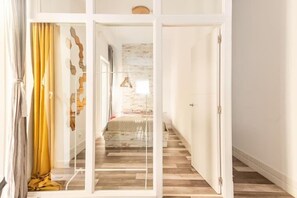 A modern interior with a wooden floor, a bed with a white headboard, and a staircase leading to another room. - San Fernando Garden (Alicante (Alacant))