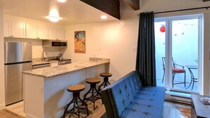 A modern kitchen with a built-in island, stainless steel appliances, and bar stools. - New Listing -- Modern on the Mtn -- Steps to Ski! (Steamboat Springs)
