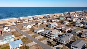 A coastal residential area with houses, a beach, and a pier. - Ocean Views with a 1 minute walk to beach access! Linens & Bath Towels included! (Kill Devil Hills)