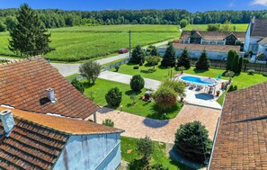 Relax in a serene, setting surrounded by lush greenery and a spacious backyard with a swimming pool.