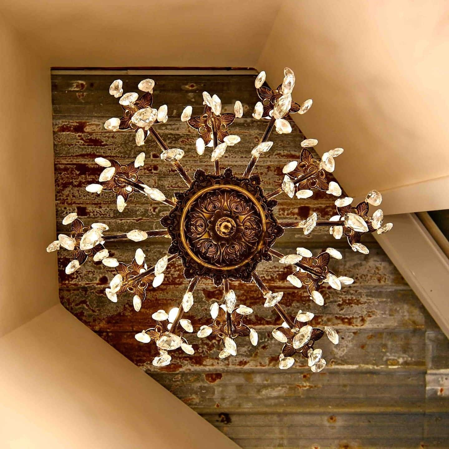 A chandelier with a central ornate design and multiple crystal elements.