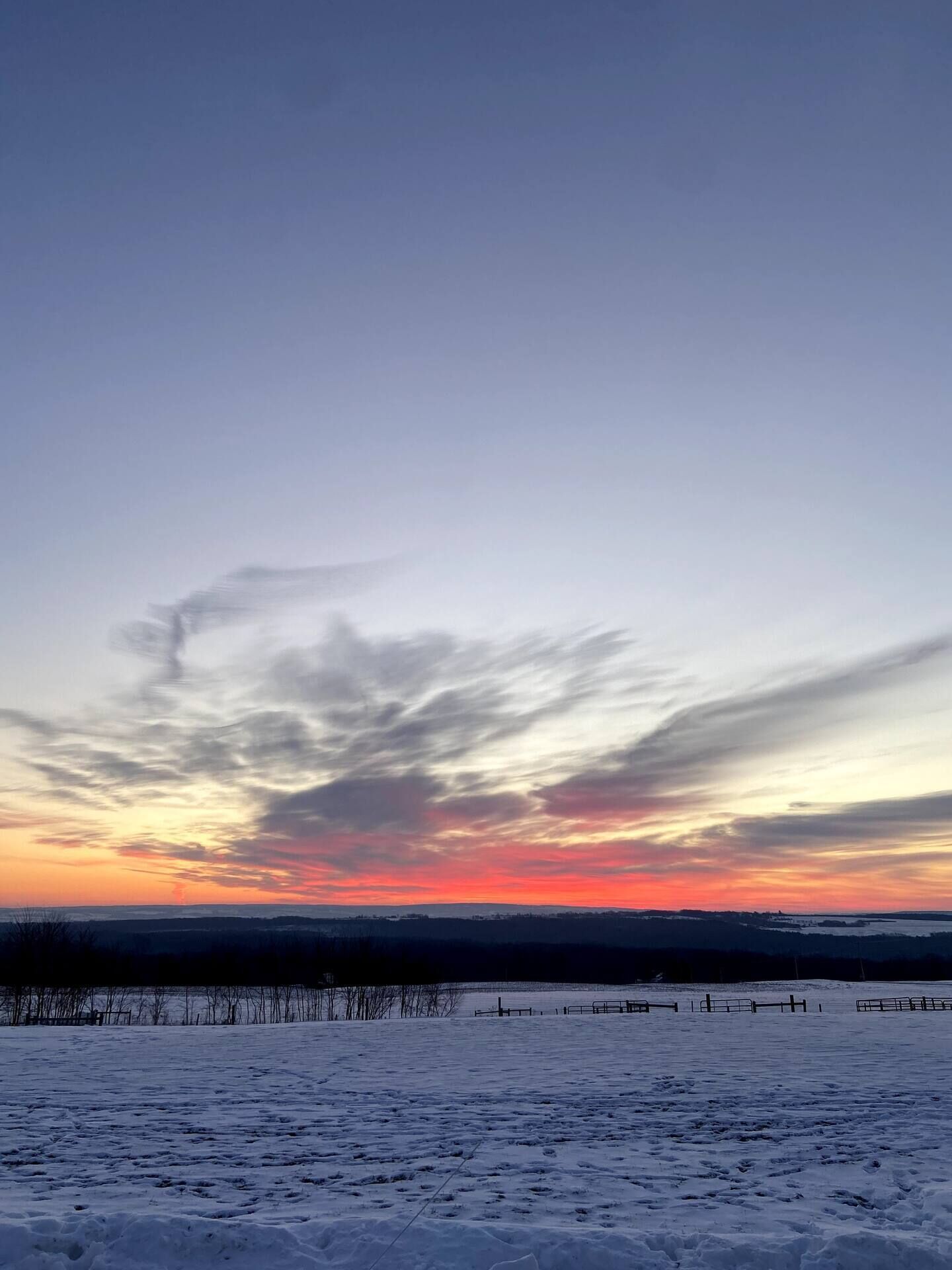 A snowy landscape with a sunset sky.