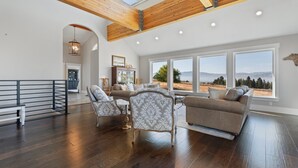 A spacious living area with a high ceiling, large windows, and a view of the outdoors. - Stunning views, sleeps 10, firepit, decks, hot tub (Heber City)
