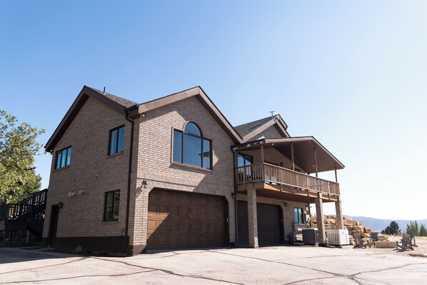 Une maison à deux étages avec un garage, un balcon et un patio.