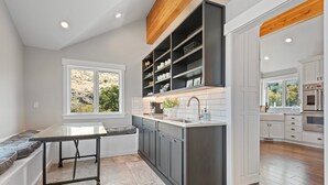 A modern kitchen with a central island, built-in cabinets, and a view of the outdoors. - Stunning views, sleeps 10, firepit, decks, hot tub (Heber City)