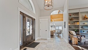 A spacious hallway with a marble floor, a wooden door with glass panels, and a modern chandelier. - Stunning views, sleeps 10, firepit, decks, hot tub (Heber City)