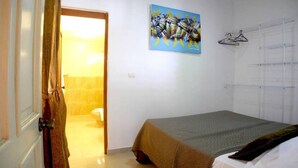 A bedroom with a bed, a painting, and a wardrobe. - Nice & Cosy Apartm. for max. 4 Guests next to Pool (Sosua)